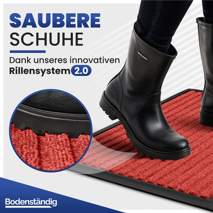 Person in schwarzen Gummistiefeln steht auf roter Fußmatte, Text: Saubere Schuhe dank Rillensystem 2.0