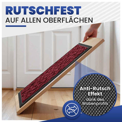dunkelrote fussmatte mit blattmuster zeigt rutschfesten halt auf allen oberflaechen dank wabenprofil hand haelt brett mit matte schraeg