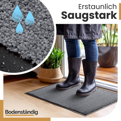 Person in nassen Gummistiefeln steht auf grauer Fußmatte, Nahaufnahme des Flors mit Wassertropfen, Text: Erstaunlich saugstark