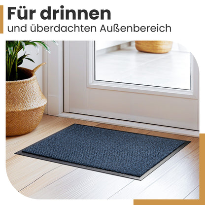 Blaue Fußmatte im Eingang vor weißer Tür auf Holzboden, Text: Für drinnen und überdachten Außenbereich