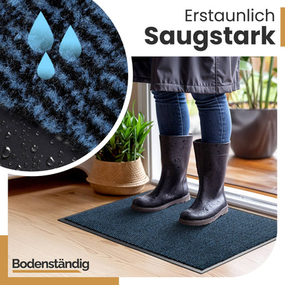 Person in nassen Gummistiefeln steht auf blauer, saugstarker Fußmatte, Detailansicht mit Wassertropfen, Logo Bodenständig
