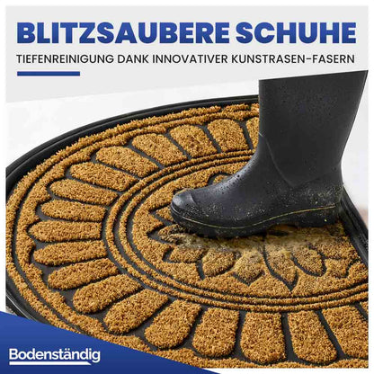Halbrunde beige Eingangsmatte mit Kunstrasen-Fasern. Ein Gummistiefel wird von Schmutz befreit.