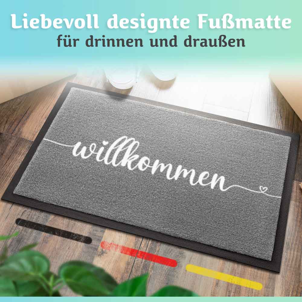 graue willkommen fussmatte auf holzboden fuer drinnen und draussen liebevoll designt mit herzlinie und farbmustern im vordergrund