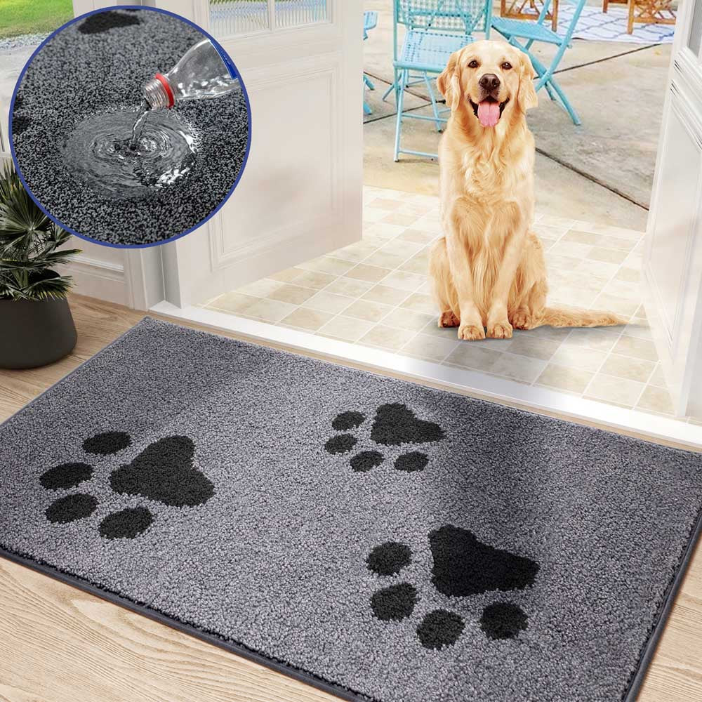 Graue, hoch saugfähige Schmutzfangmatte mit dunklem Pfotenmuster. Im Hintergrund sitzt ein Golden Retriever am Eingang.