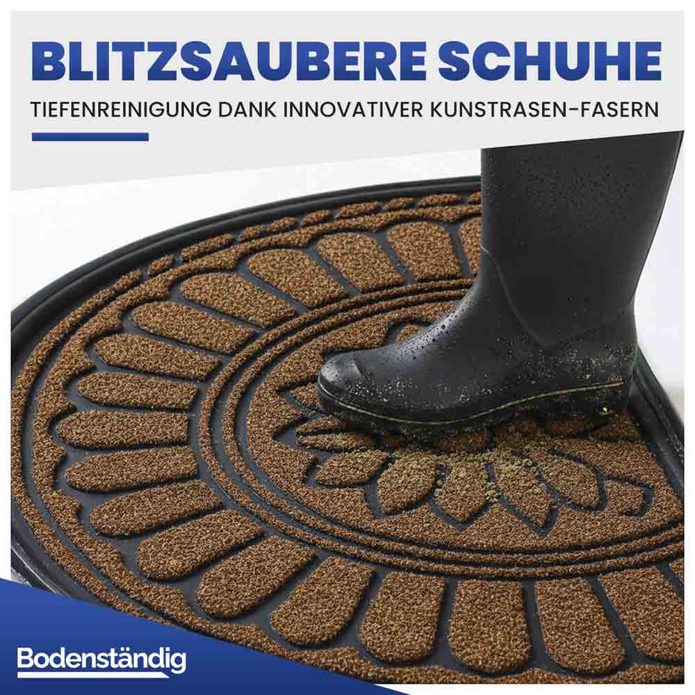 Halbrunde braune Eingangsmatte mit Kunstrasen-Fasern zur Tiefenreinigung. Ein Gummistiefel wird von Schmutz befreit.