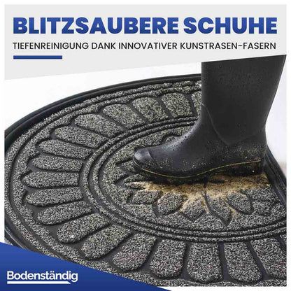 Halbrunde Eingangsmatte mit Kunstrasen-Fasern zur Tiefenreinigung. Ein Gummistiefel wird von Schmutz befreit.