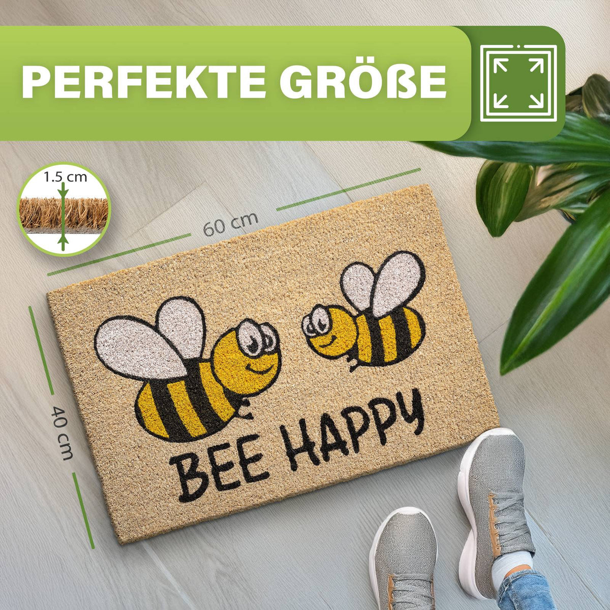 Kokosmatte „Bee Happy“ mit zwei Bienen, Maße 40 x 60 cm und 1,5 cm dick, daneben Schuhe und Zimmerpflanze