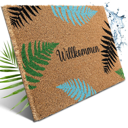 Kokos Fußmatte mit grünen, blauen und schwarzen Farnblättern und Schriftzug „Willkommen“, daneben Wasserspritzer