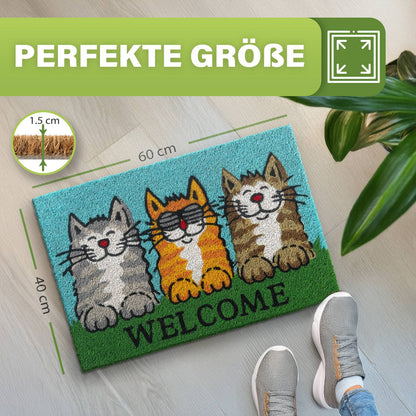Kokos Fußmatte Welcome Cats mit drei Katzen, Maße 40 x 60 cm und 1,5 cm Dicke, daneben Füße und Zimmerpflanze