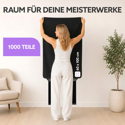Frau hält eine schwarze Puzzlematte, 60 x 100 cm für 1000 Teile, im Wohnraum vor einer Wand hoch