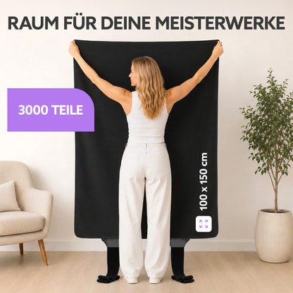 Frau hält schwarze Puzzlematte 100 x 150 cm hoch, Text: Raum für deine Meisterwerke, 3000 Teile