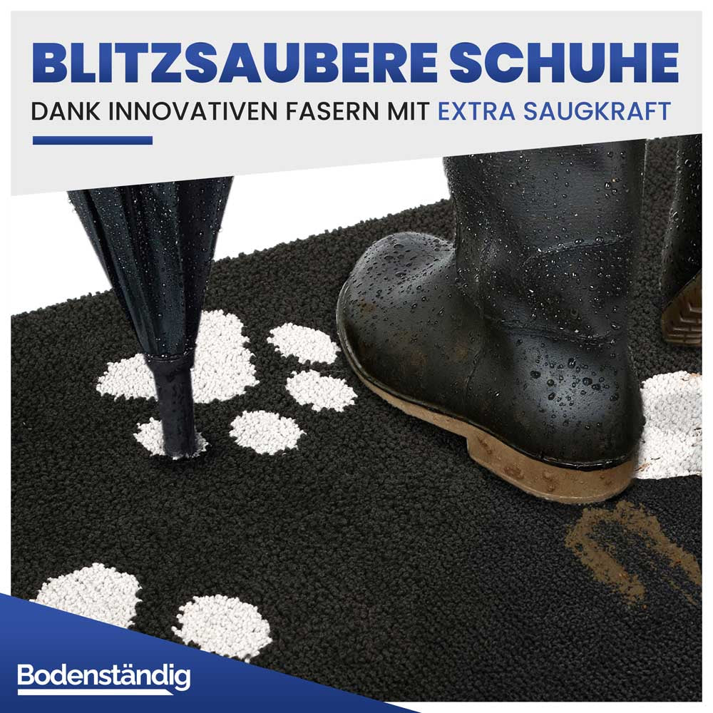 Schwarze Schmutzfangmatte mit Gummistiefeln und Regenschirm, demonstriert extra Saugkraft für blitzsaubere Schuhe.