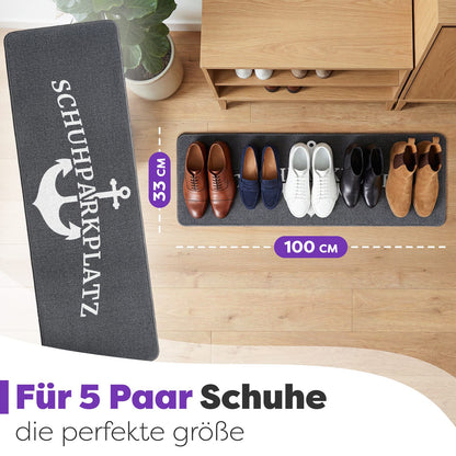 Graue Schuhparkplatz-Fußmatte mit Anker von oben, darauf fünf Paar Schuhe, Maße 33 x 100 cm