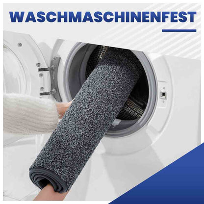 Waschmaschinenfeste, graue Fußmatte wird zur einfachen Reinigung in die Waschmaschine gelegt.