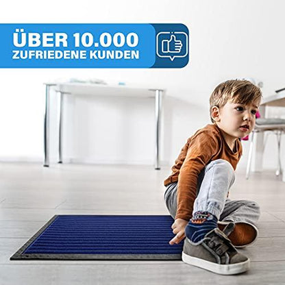 Kind sitzt auf einer blauen Fussmatte im hellen Raum, die rutschfest ist und von vielen zufriedenen Kunden gewaehlt wird.