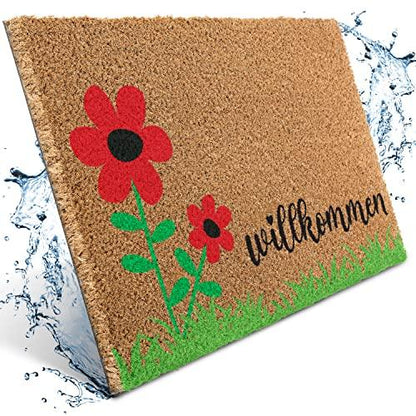 Natürliche Kokos-Fußmatte mit rotem Blumen-Motiv, grünem Gras und dem Schriftzug "Willkommen". Ideal für den Eingangsbereich.