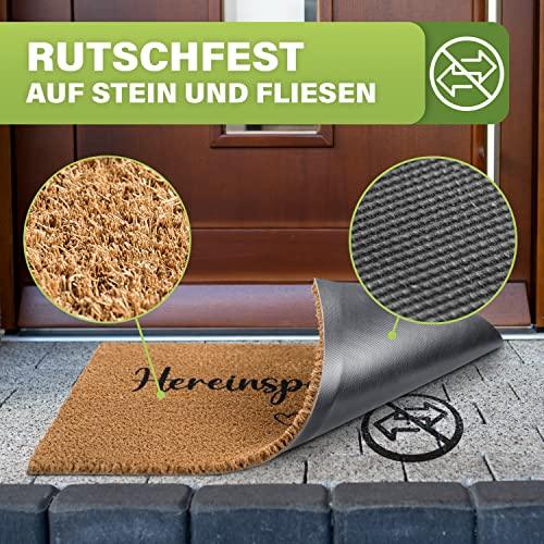 Kokos-Fußmatte "Hereinspaziert" wird hochgeklappt. Rutschfeste Gummiunterseite, ideal für Stein und Fliesen im Eingangsbereich.